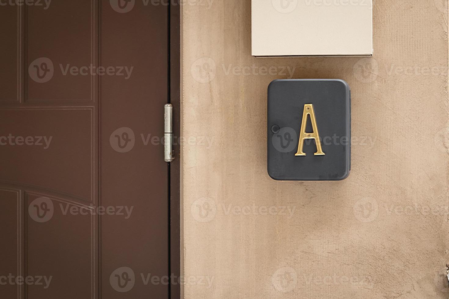 groot geel metaal brief een Aan doos in de buurt Ingang deur Aan gebouw facade foto