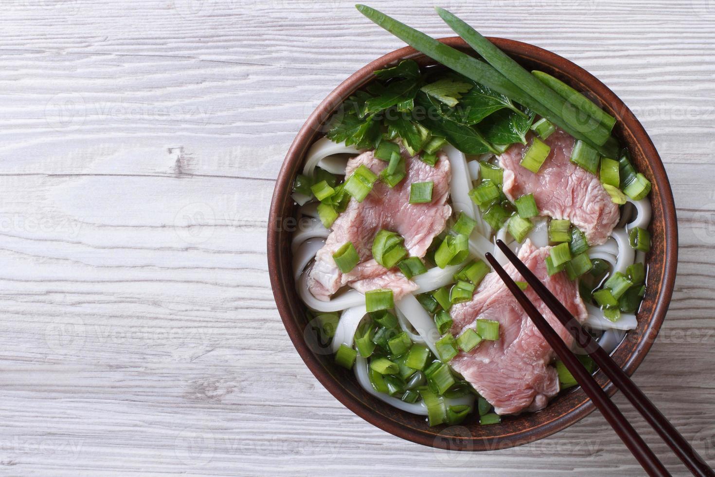 Vietnamese pho bo soep met rundvlees close-up. bovenaanzicht foto