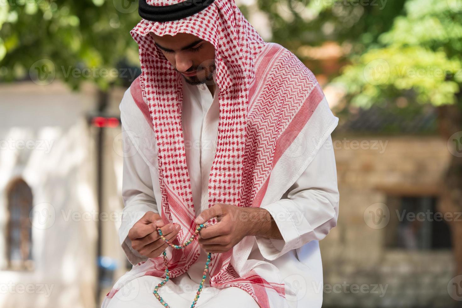 close-up van mannelijke handen bidden met rozenkrans foto