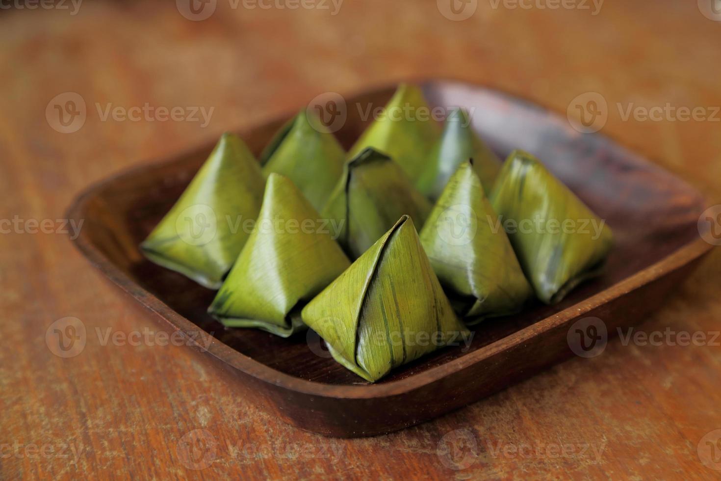 Thais dessert verpakt in bananenbladeren op houten schotel. foto