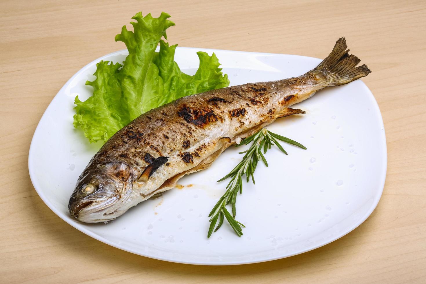 gegrilde forel op de plaat en houten achtergrond foto