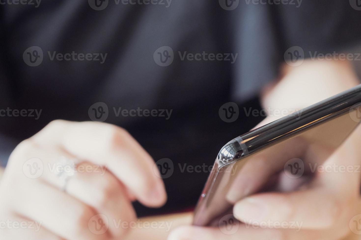 vrouw met diamanten ring bij de hand met smartphone in café-restaurant foto