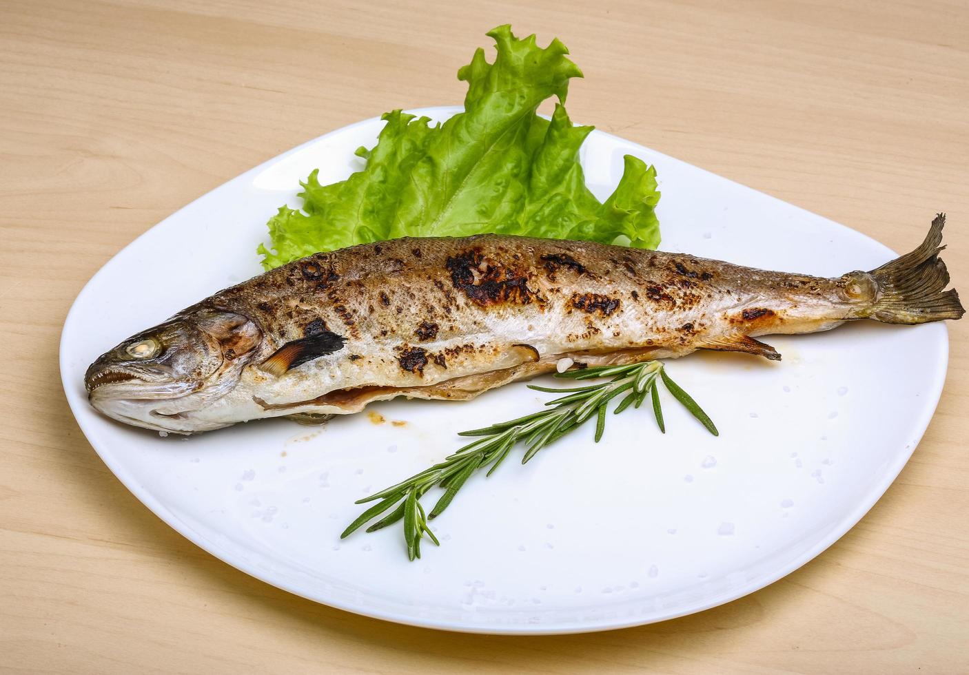 gegrilde forel op de plaat en houten achtergrond foto