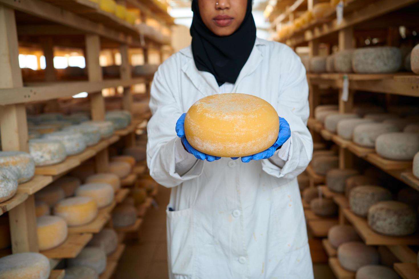 Afrikaanse zwart moslim bedrijf vrouw in lokaal kaas productie bedrijf foto