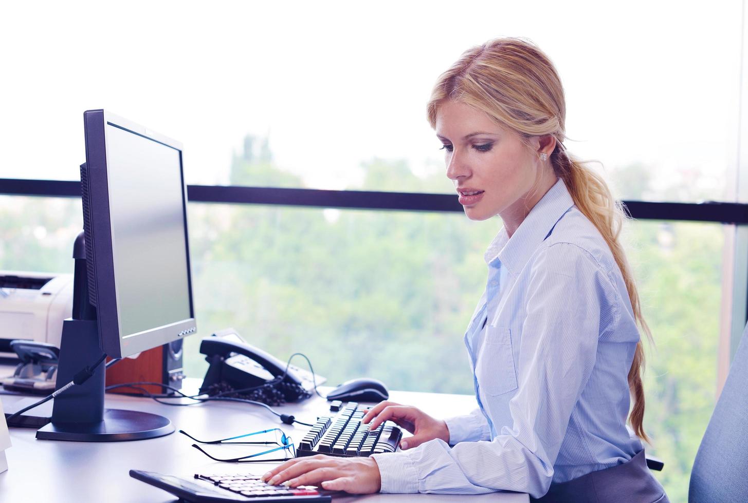 bedrijf vrouw werken Aan haar bureau in een kantoor foto