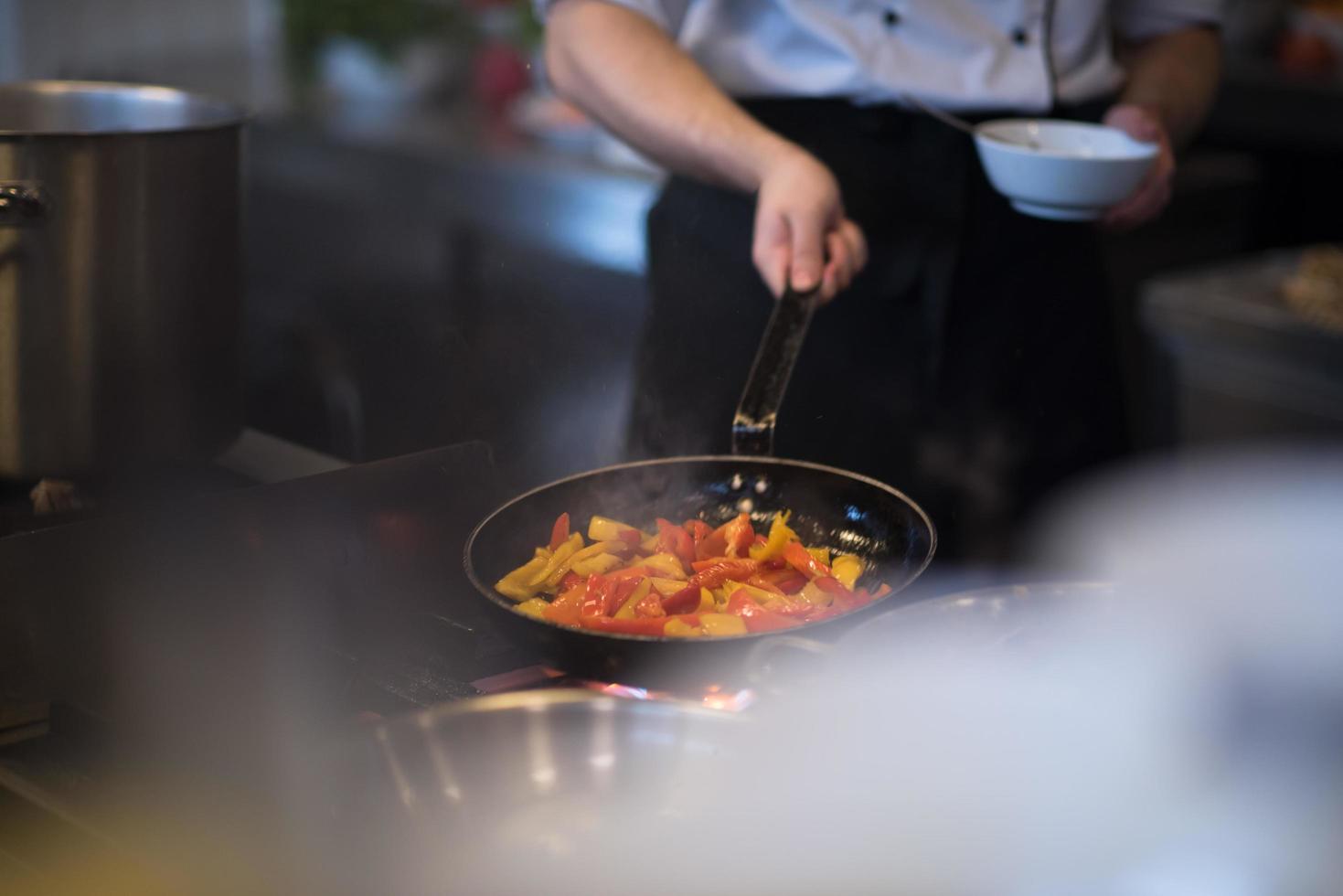 chef flippen groenten in wok foto