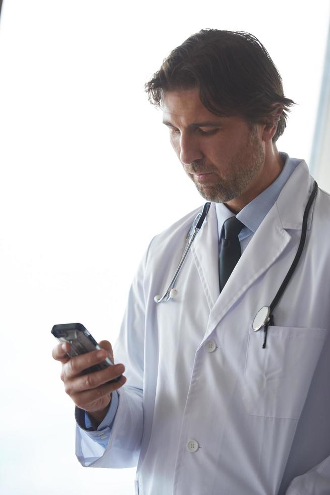 dokter sprekend Aan mobiele telefoon foto