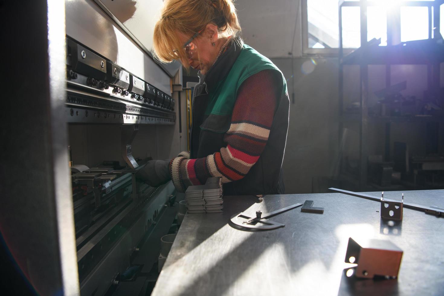 vrouw werken in een modern fabriek en voorbereidingen treffen materia voor een cnc machine. foto