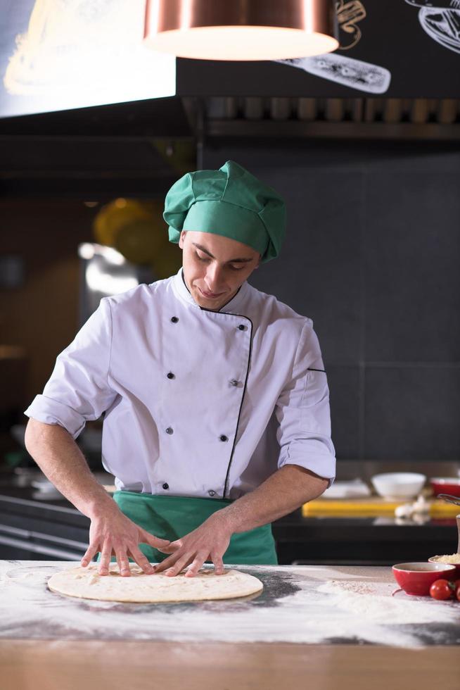 chef voorbereidingen treffen deeg voor pizza foto