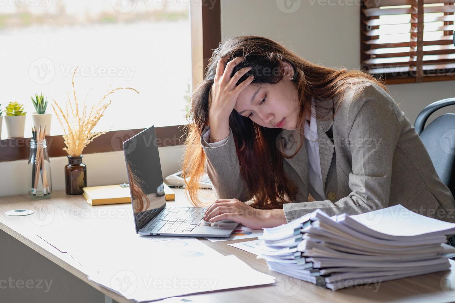 concept burn-out syndroom. zakenvrouw voelt zich ongemakkelijk bij het werken. die wordt veroorzaakt door stress, opgebouwd door onsuccesvol werk en minder rustend lichaam. raadpleeg een gespecialiseerde psychiater. foto