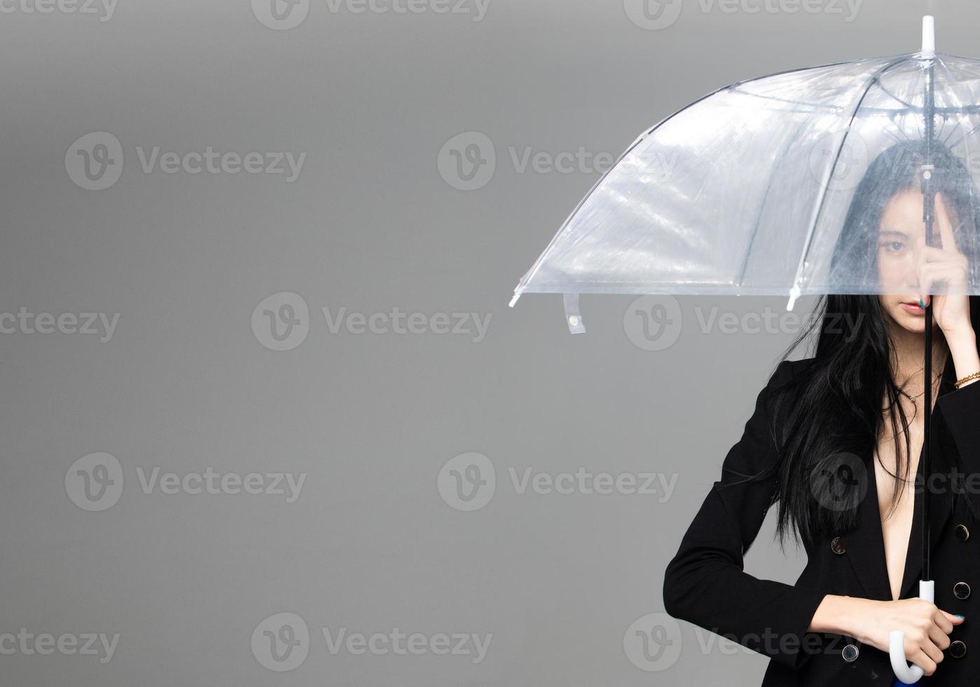 Aziatisch transgender vrouw met lang zwart Rechtdoor haar, wind blazen Gooi in de lucht. vrouw houden paraplu tegen wind storm, gevoel mode sensueel sexy, grijs achtergrond geïsoleerd kopiëren ruimte foto