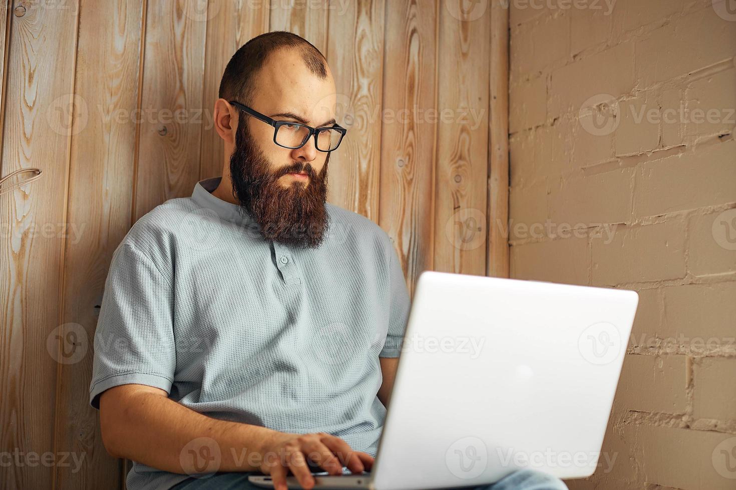 levensstijl geslaagd freelancer Mens met baard behaalt nieuw doel met laptop in zolder interieur. foto