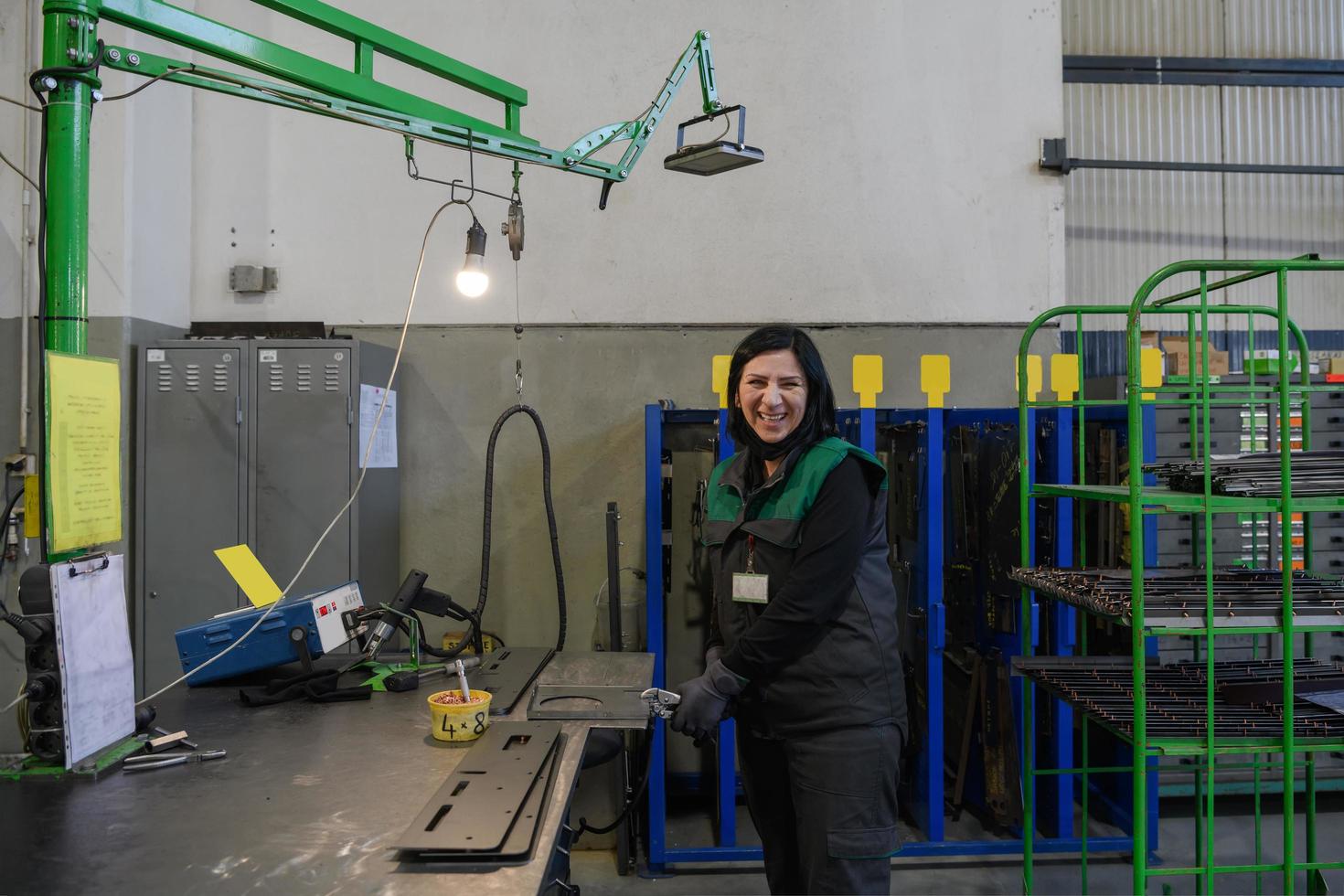 een vrouw werken in de modern metaal productie en verwerken industrie lassen de Product en bereidt zich voor het voor een cnc machine foto