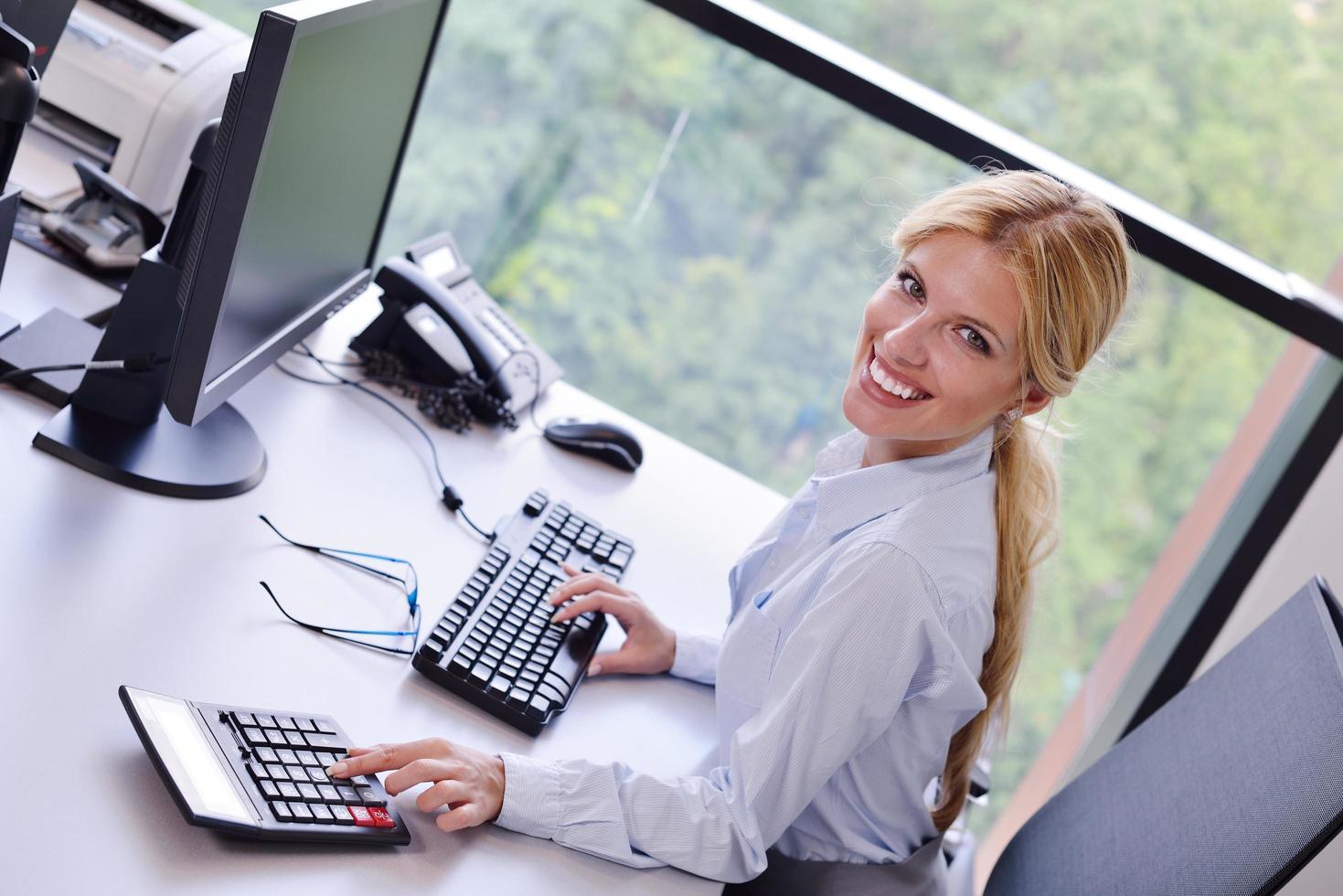 bedrijf vrouw werken Aan haar bureau in een kantoor foto