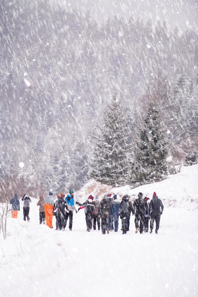 groep van jong mensen wandelen door mooi winter landschap foto