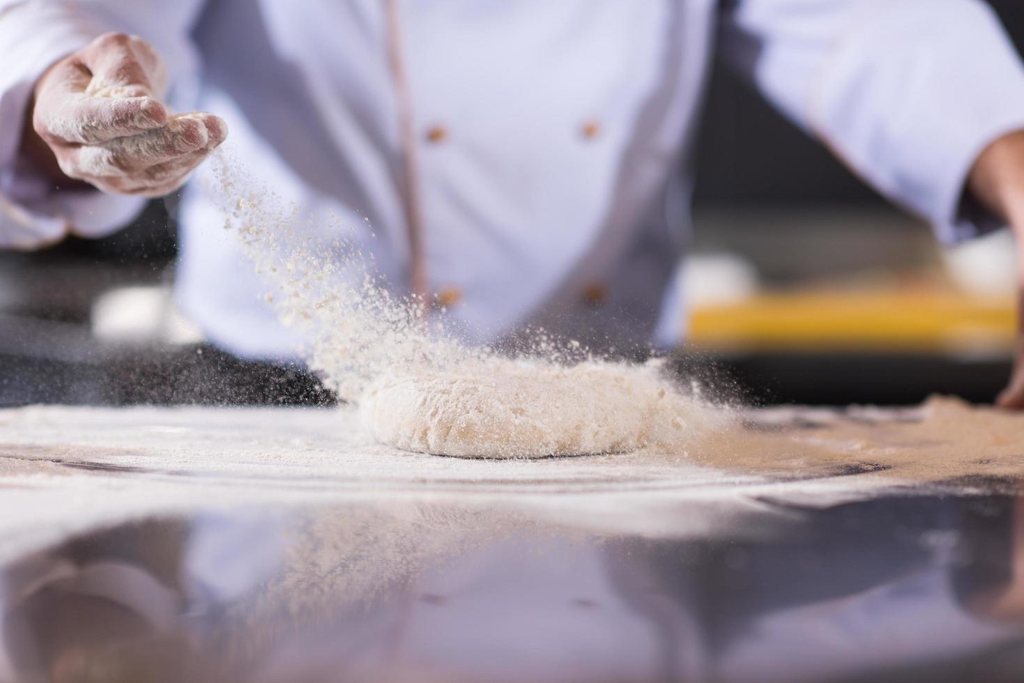 chef handen voorbereidingen treffen deeg voor pizza foto