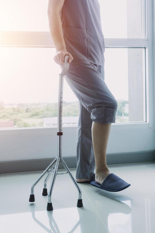 jong Aziatisch fysiek therapeut werken met senior vrouw Aan wandelen met een wandelaar foto