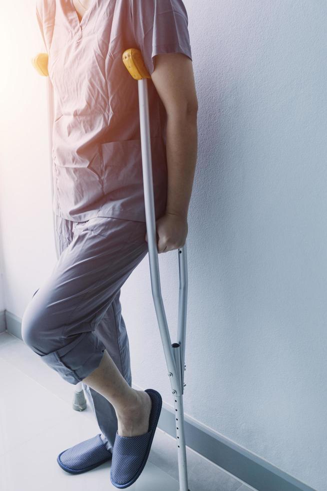 jong Aziatisch fysiek therapeut werken met senior vrouw Aan wandelen met een wandelaar foto