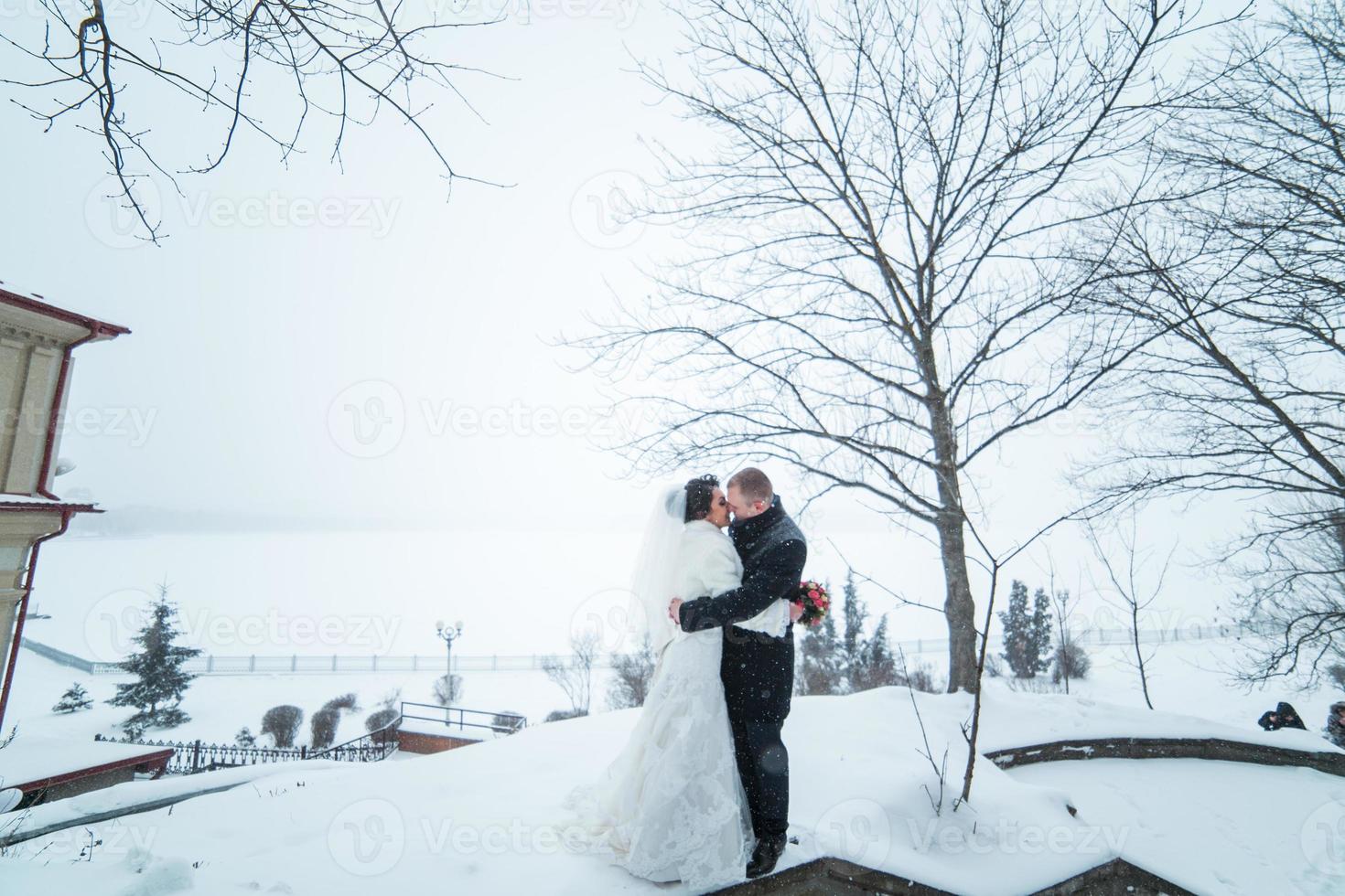 bruid en bruidegom lopen op de stad in de sneeuw foto