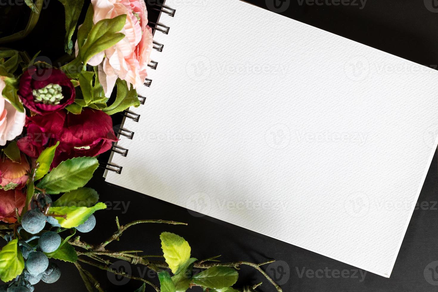 schetsboek met kleurrijk boeket en bosbes Aan zwart bord achtergrond in vlak leggen ontwerp. foto