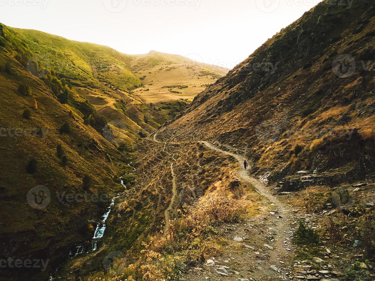 vrouw wandeltocht naar beneden in Kazbegi nationaal park Gergeti gletsjer spoor traject solo wandeltocht buitenshuis vrouw foto