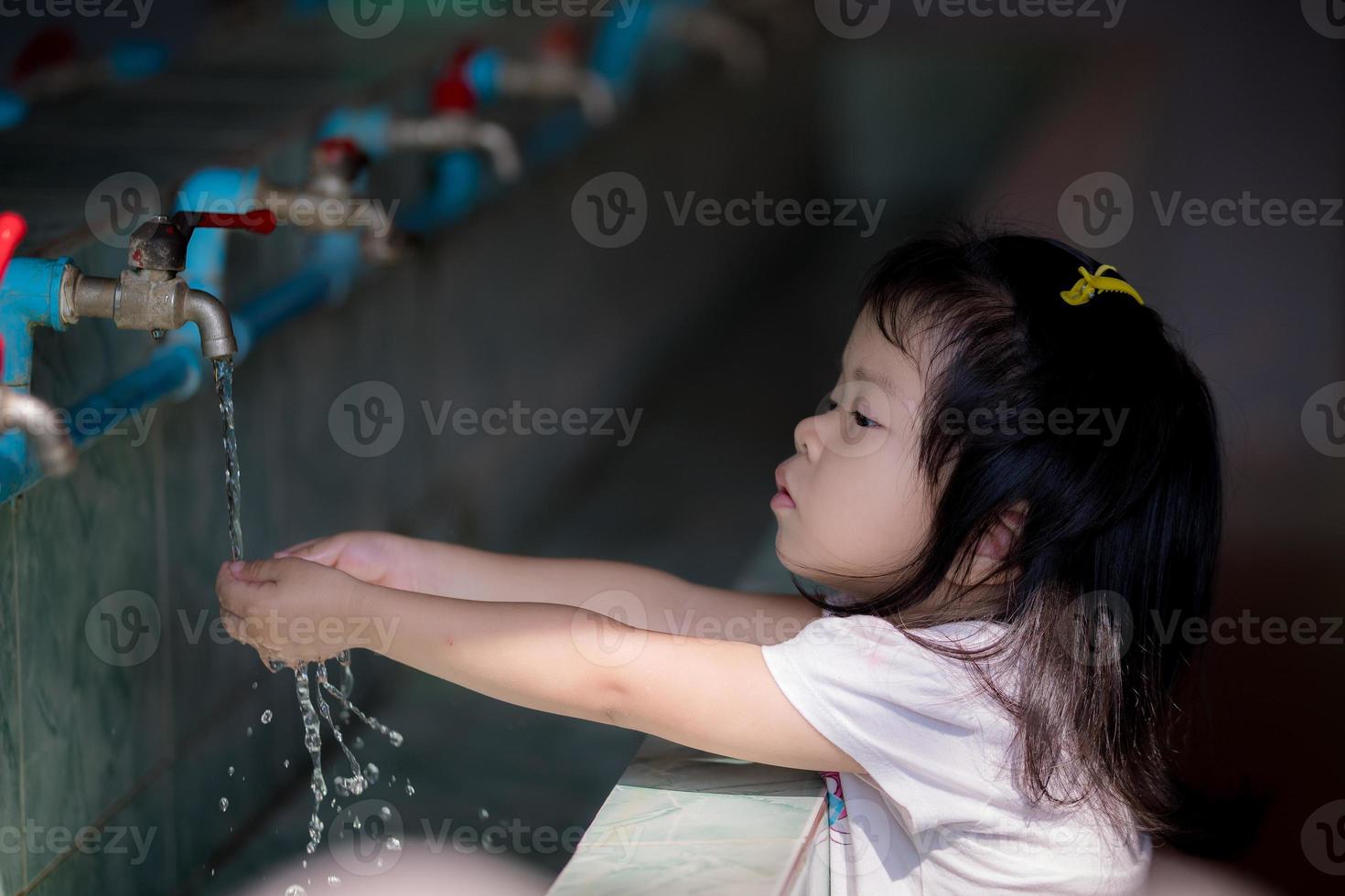 portret beeld kind 3-4 jaren oud. Aziatisch meisje wassen haar handen met kraan Bij kleuterschool school, na baby spelen speelplaats. leeg ruimte voor binnengaan tekst. foto