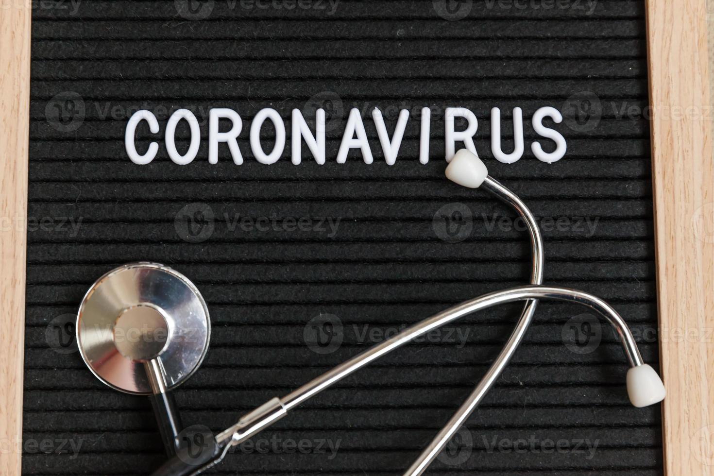 tekstuitdrukking coronavirus en stethoscoop op zwarte letterbordachtergrond. nieuw coronavirus 2019-ncov, mers-cov midden-oosten respiratoir syndroom coronavirus afkomstig uit Wuhan China foto