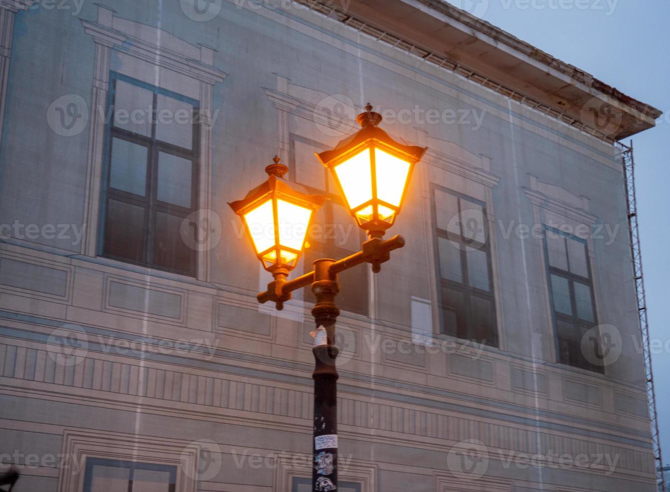 lit stengel lantaarn tegen de backdrop van een gebouw onder restauratie. foto