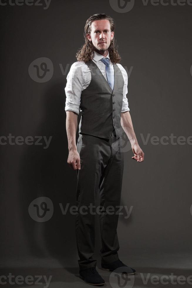 jonge man lang haar expressief gezicht dragen pak en stropdas. foto