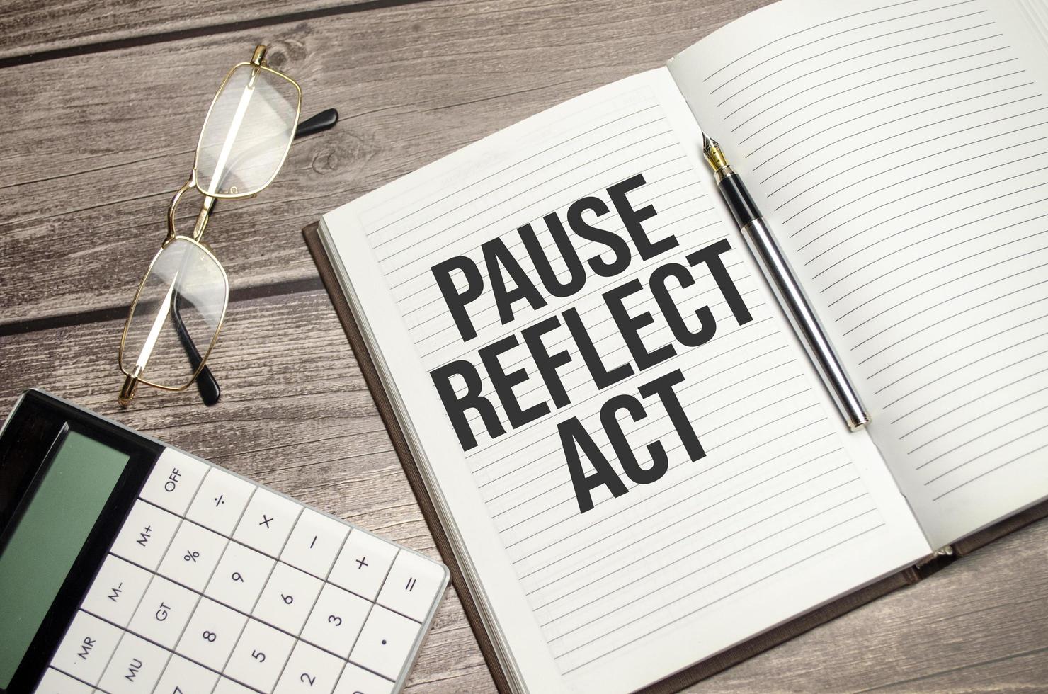 pauze, reflecteren, handelen concept woorden Aan kladblok en rekenmachine en houten achtergrond foto