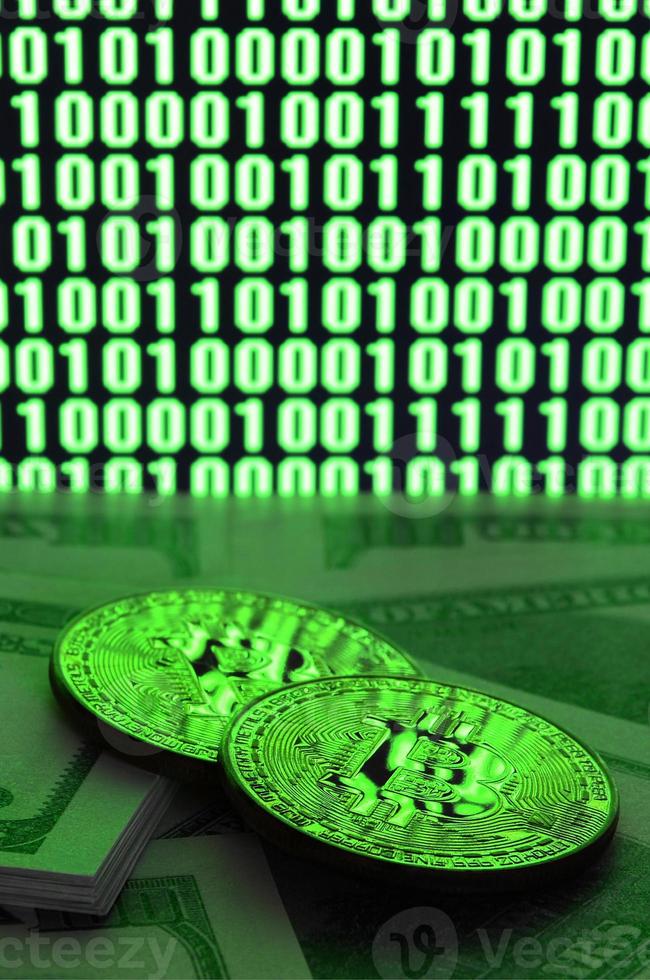 twee bitcoins leugens Aan een stapel van dollar rekeningen Aan de achtergrond van een toezicht houden op beeltenis een binair code van helder groen nullen en een eenheden Aan een zwart achtergrond. laag sleutel verlichting foto