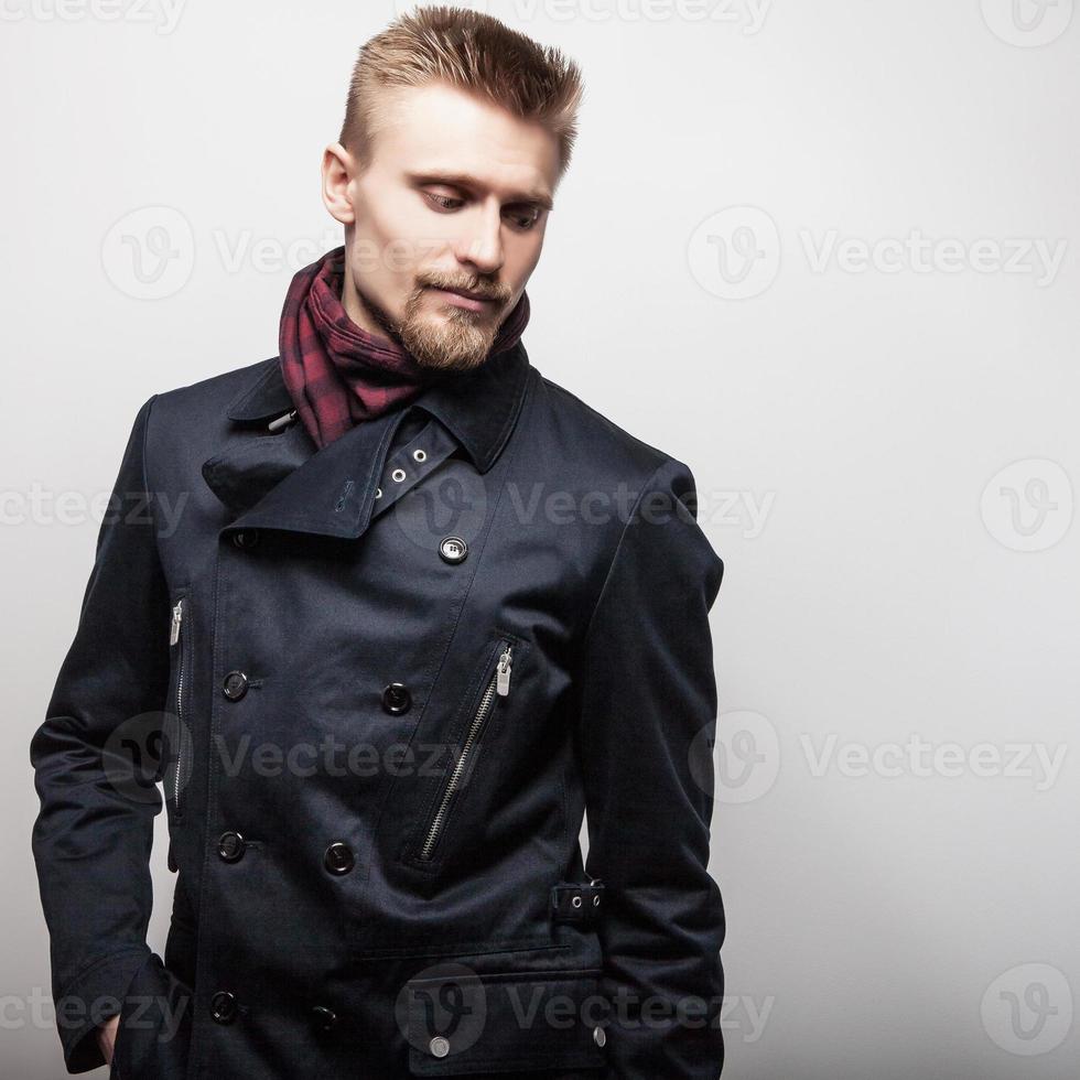 elegante jonge knappe man in zwarte jas. studio mode portret. foto
