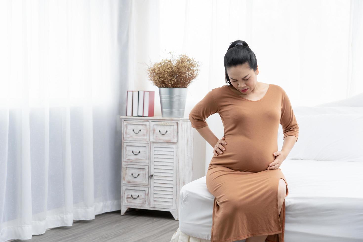 zwangere vrouw die thuis rugpijn voelt foto