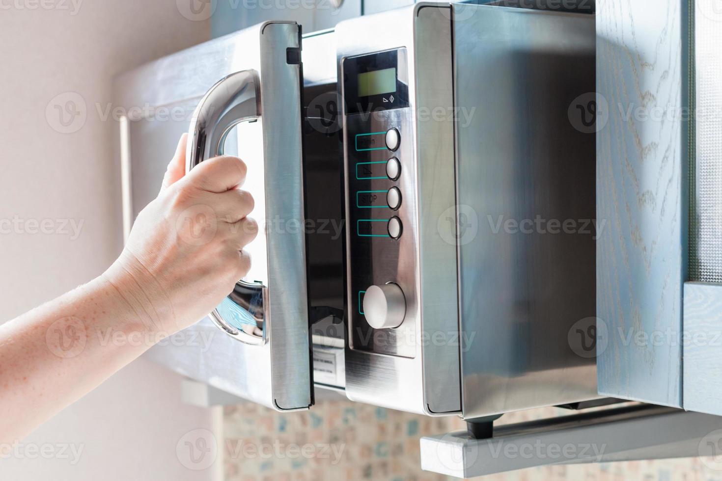 hand- opent magnetronoven oven voor verwarming voedsel foto