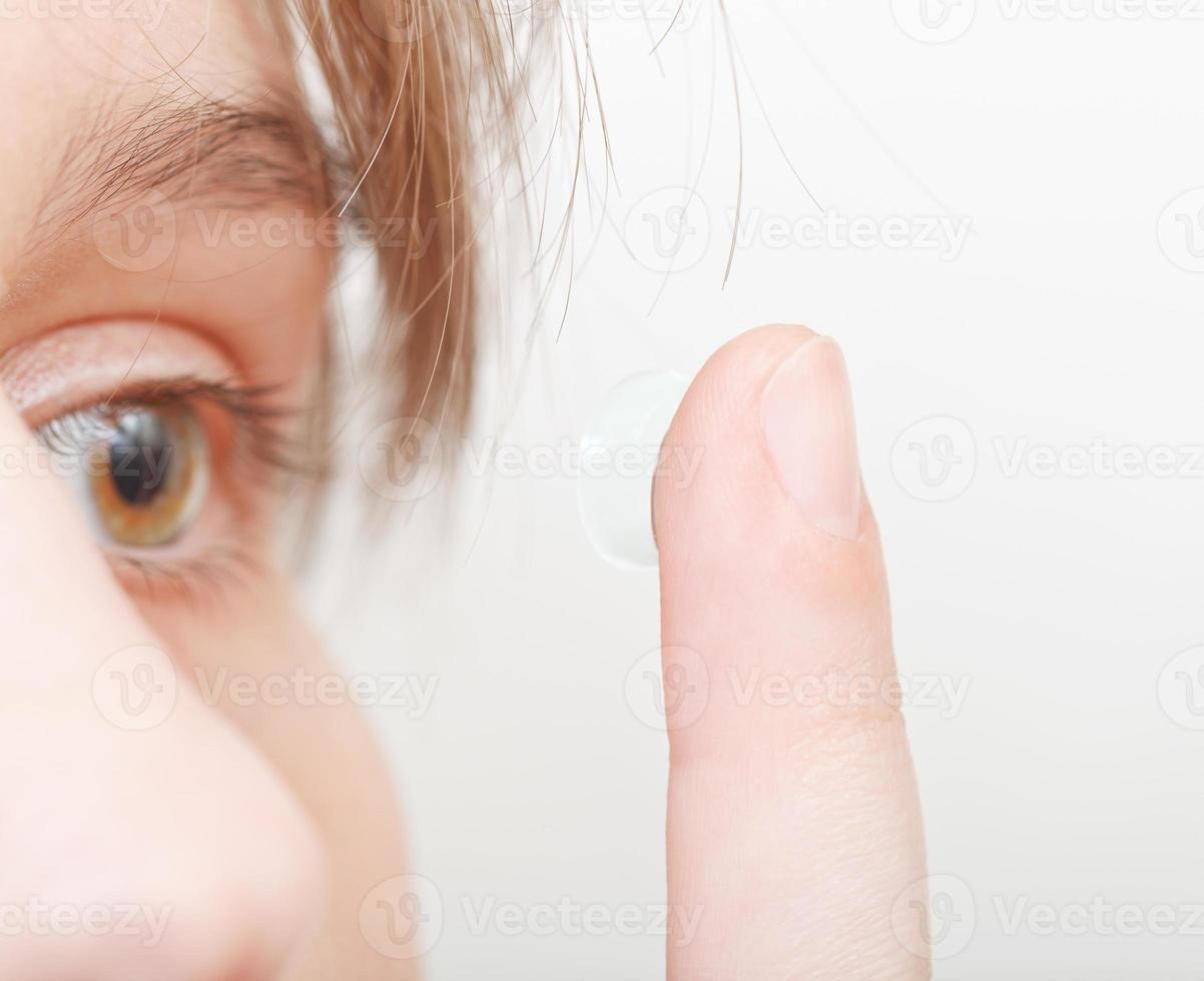 vrouw inzetstukken contact lens in oog foto