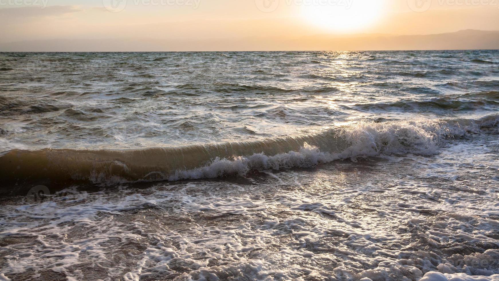 zonsondergang en surfen Bij dood zee in winter schemer foto