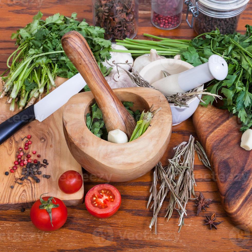 mortieren, Groenen en droog specerijen Aan houten tafel foto