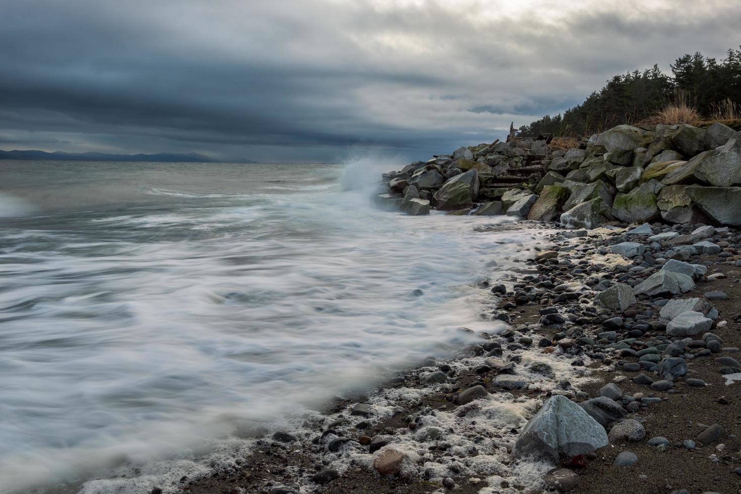 rotsachtige kust onder bewolkte hemel foto