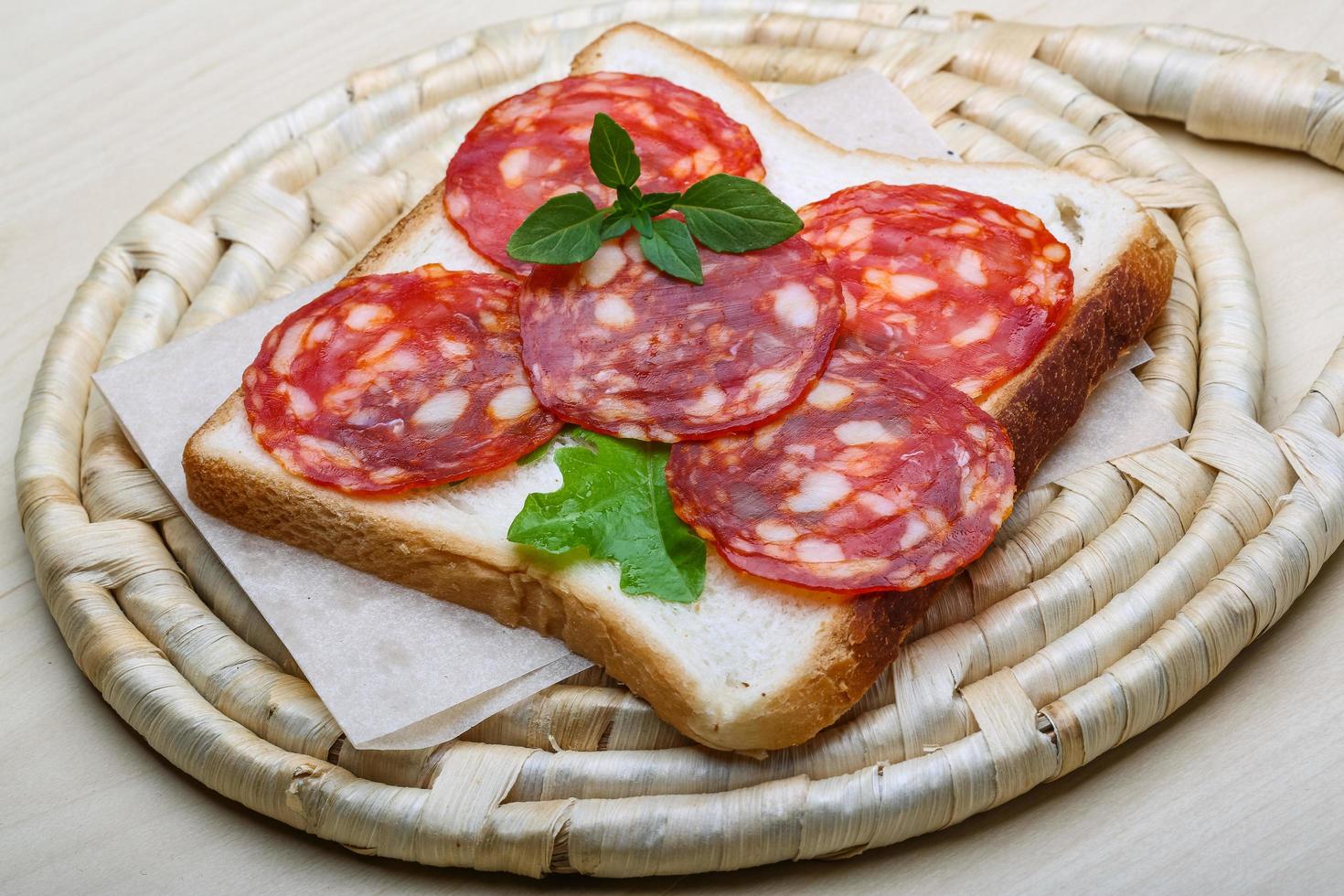 salami belegd broodje Aan houten bord en houten achtergrond foto