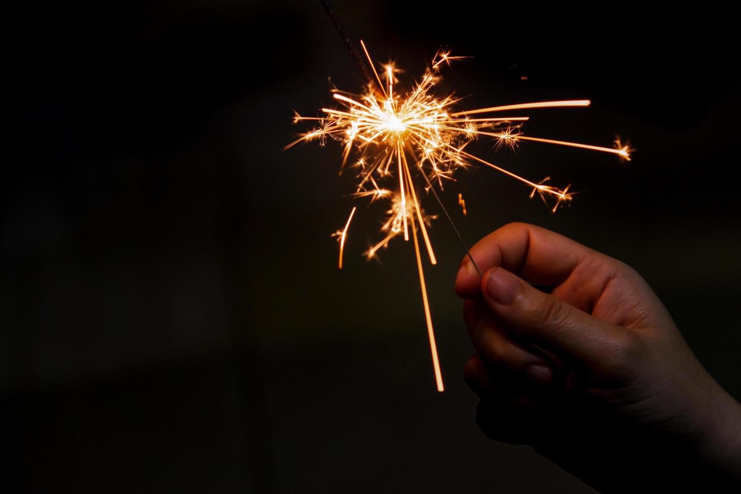 vrouwelijke hand met een brandende sterretje, Kerstmis en Nieuwjaar sparkler vakantie achtergrond foto