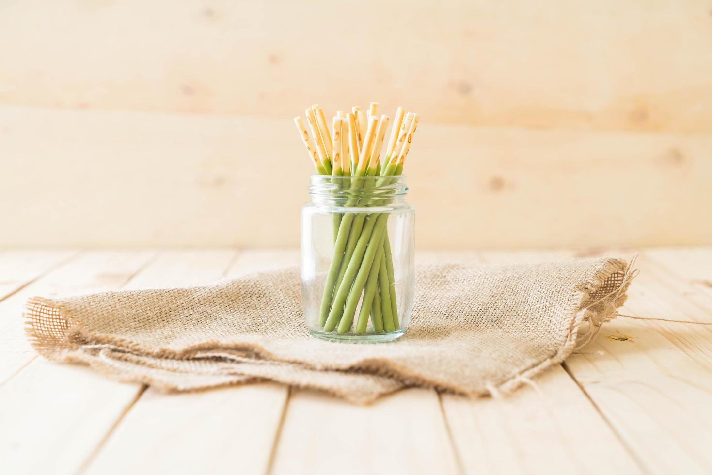 matcha groene thee bedekte koekjesstokken in glazen pot foto