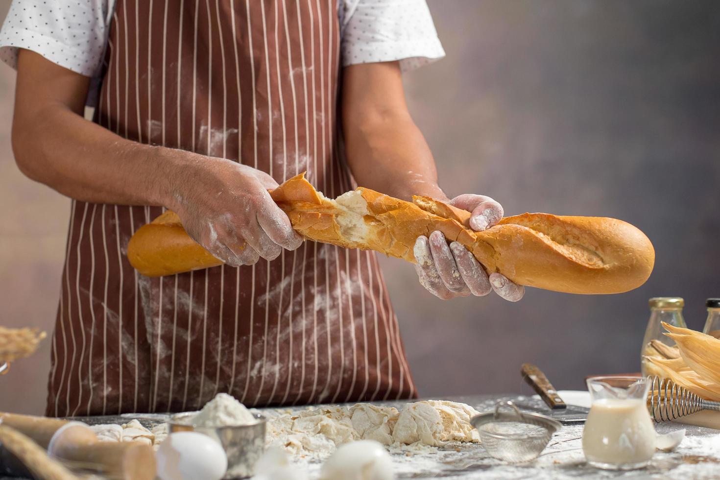 chef-kok trekt vers brood in de keuken foto