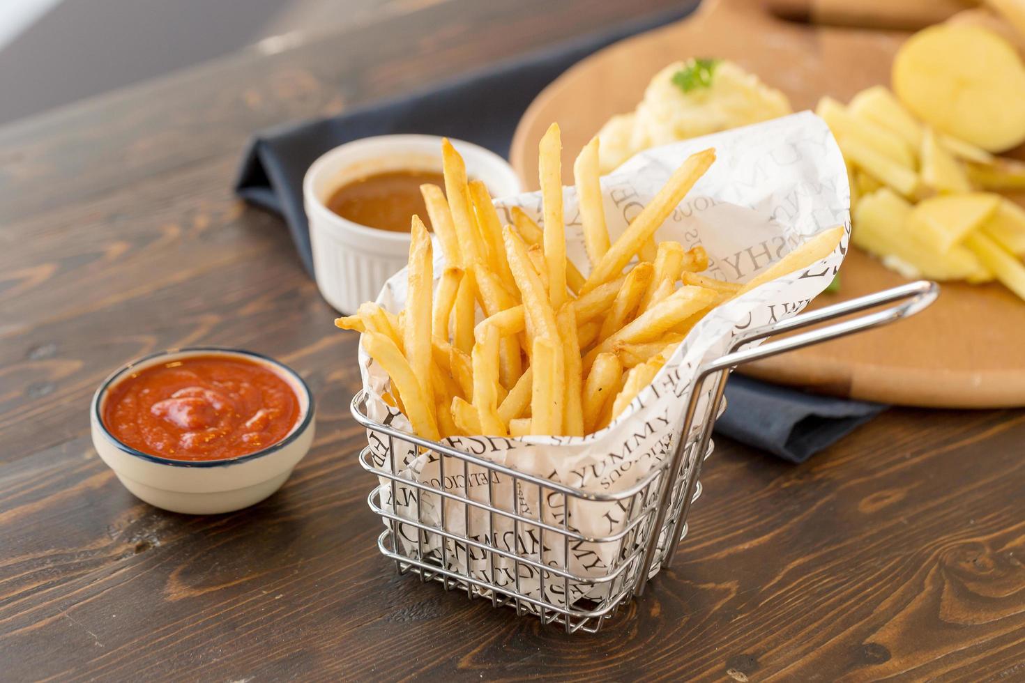 Franse frietjes met ketchup op houten tafel foto
