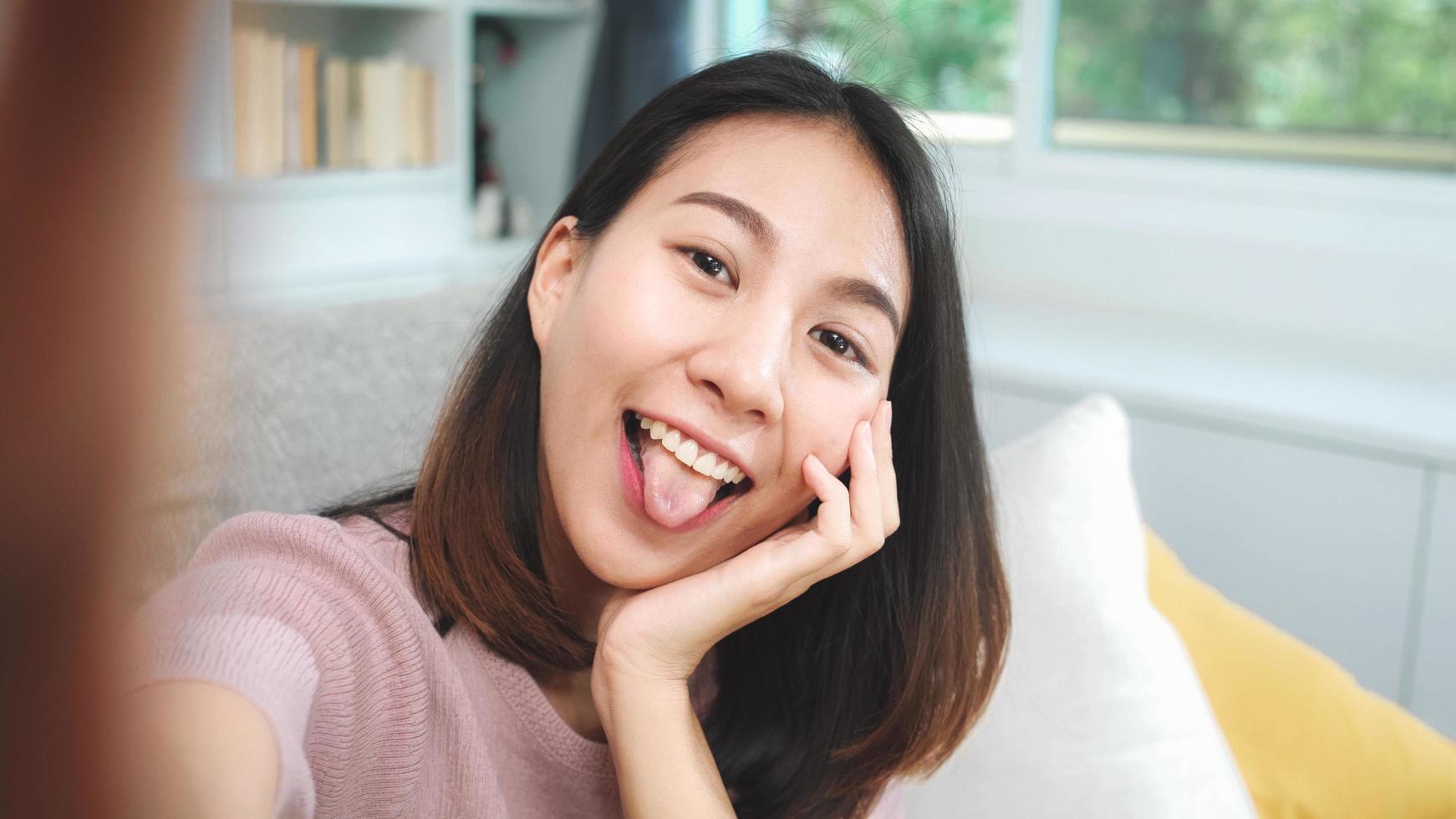 jonge Aziatische vrouwelijke tiener die technologie thuis gebruikt foto