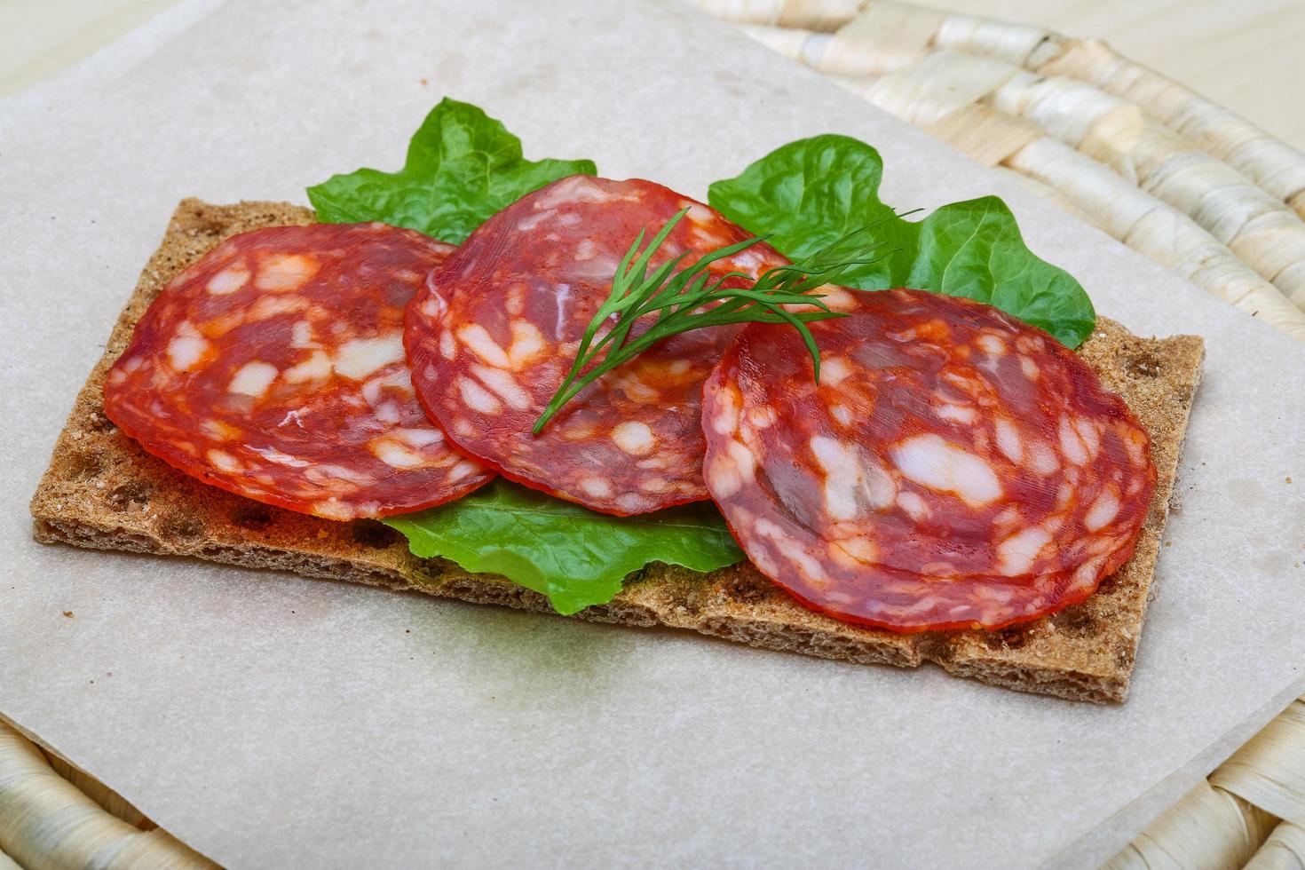 salami belegd broodje Aan houten bord en houten achtergrond foto