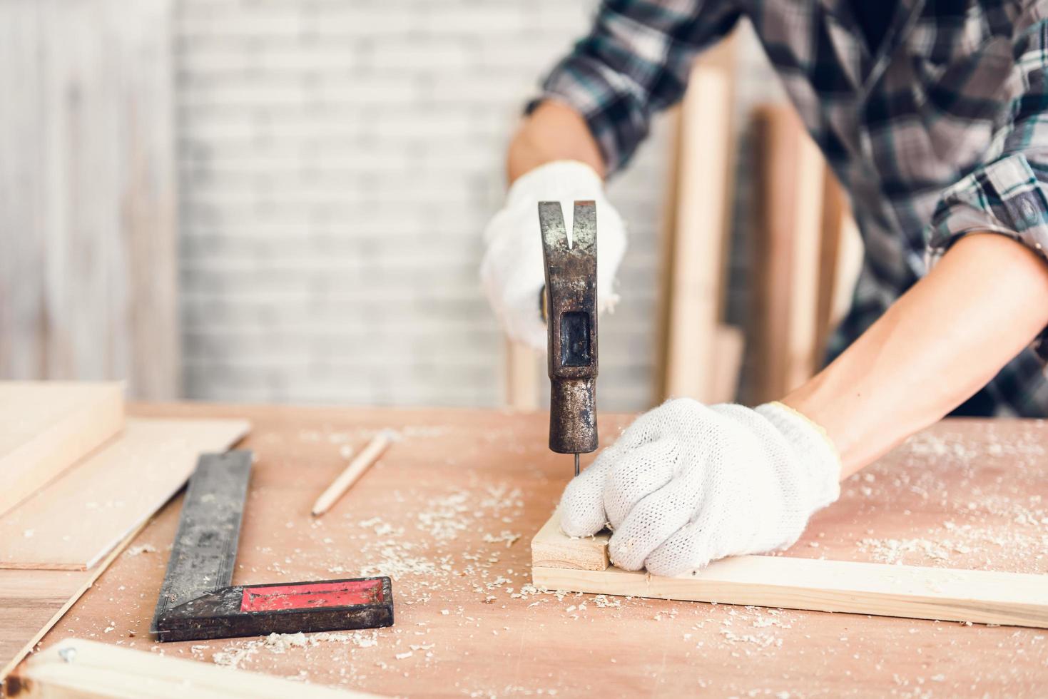 man nagel hameren in hout foto