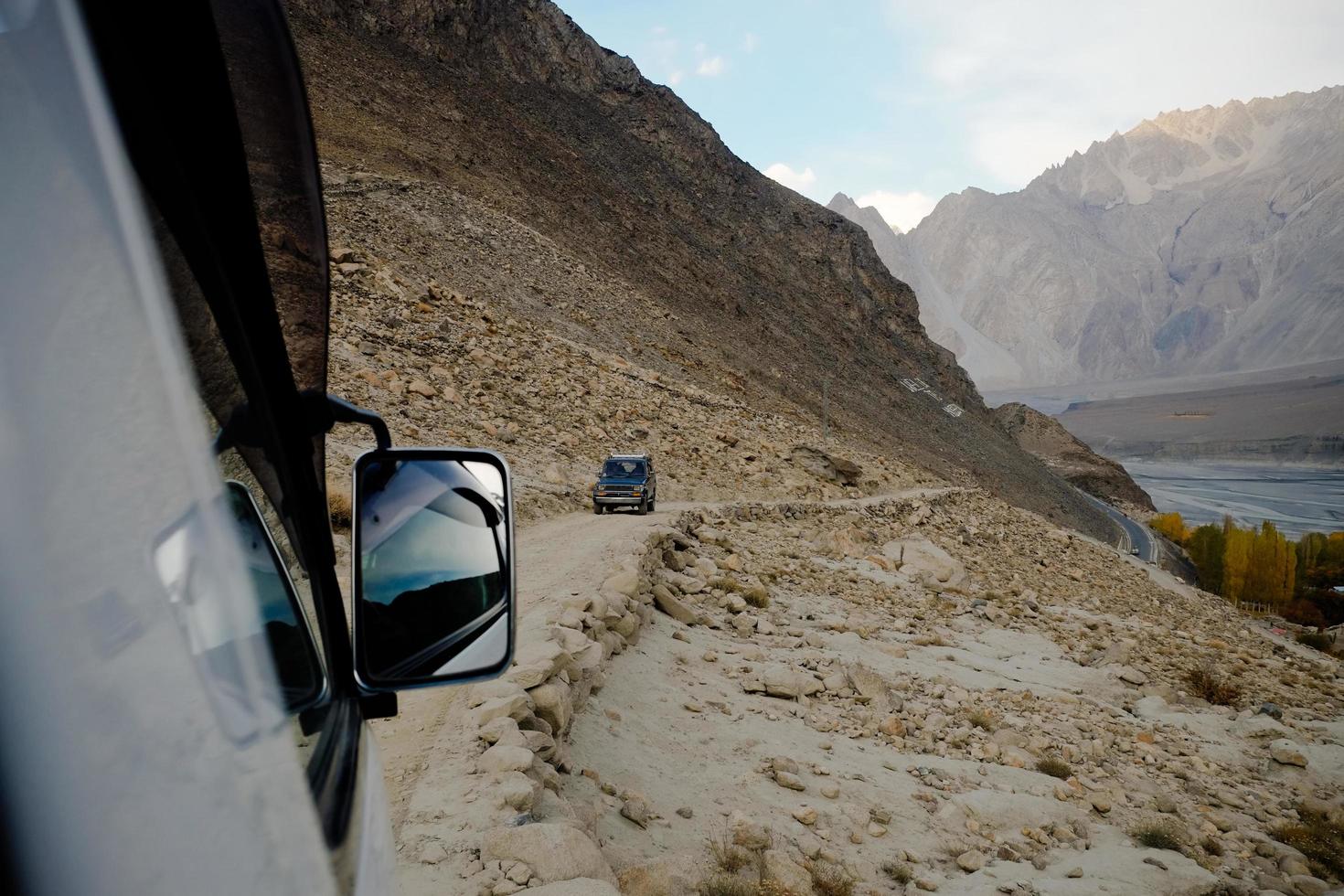 mensen rijden off-road voertuig langs karakoram berg foto