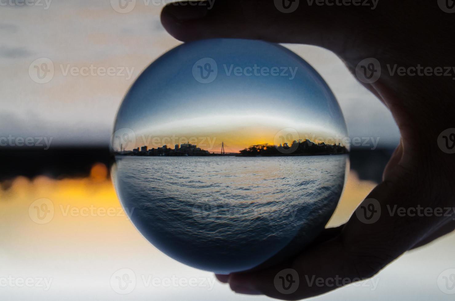 silhouet van stadsgezicht met oceaan visie fotografie glas bal. foto