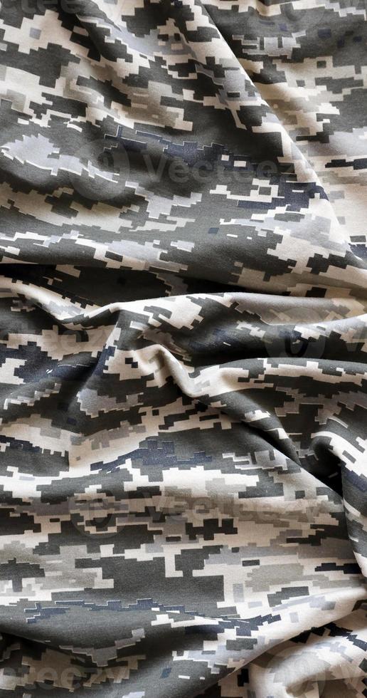 kleding stof met structuur van oekraïens leger korrelig camouflage. kleding met camo patroon in grijs, bruin en groen pixel vormen. officieel uniform van oekraïens soldaten foto