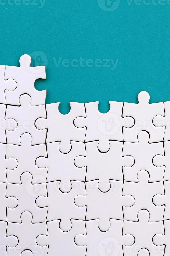 fragment van een gevouwen wit decoupeerzaag puzzel Aan de achtergrond van een blauw plastic oppervlak. structuur foto met kopiëren ruimte voor tekst